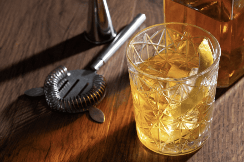 A glass of bourbon placed on a table