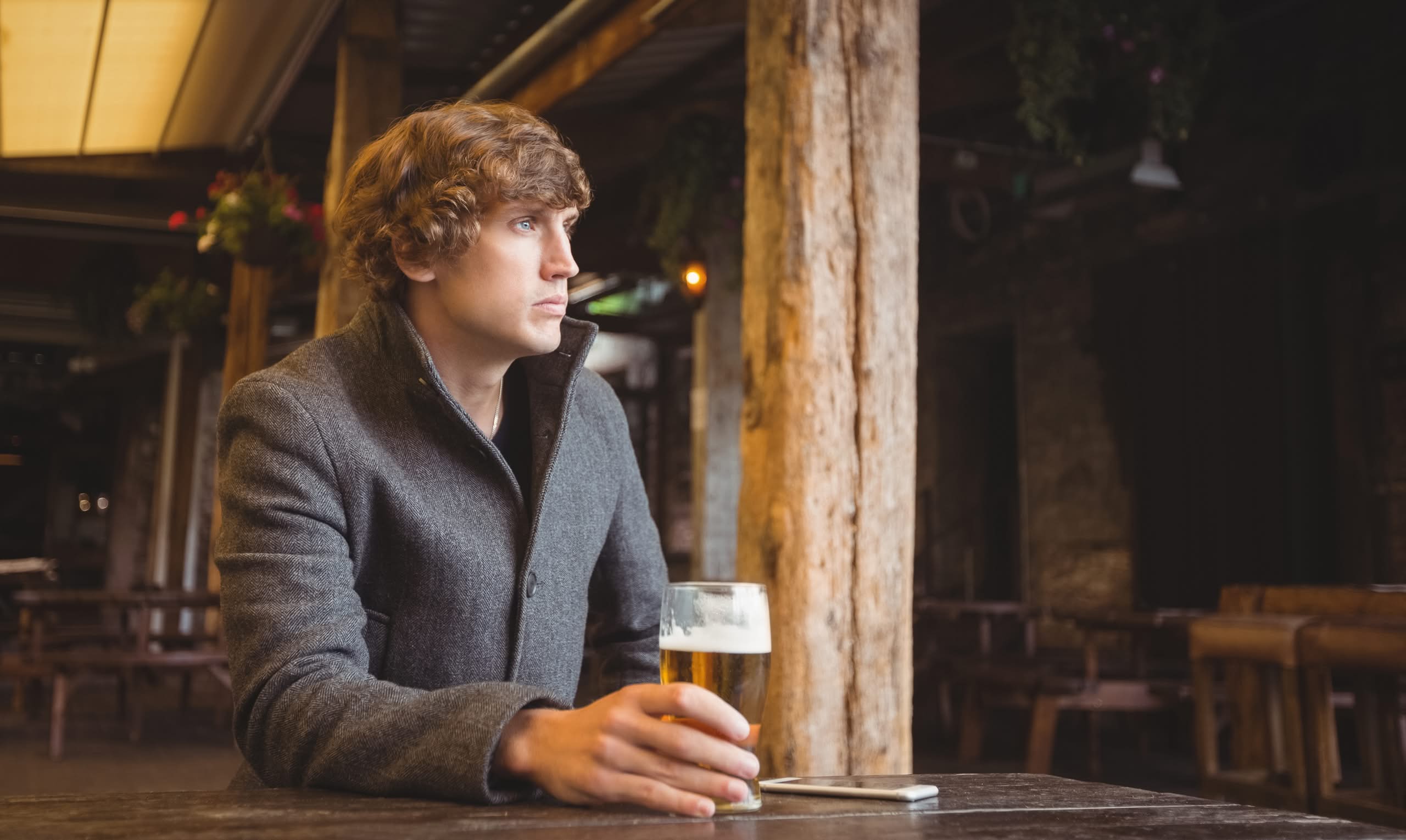 A man sitting in a bar with a glass in his hand