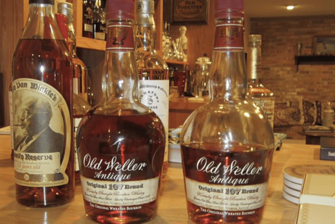 Old Weller Antique 107 bourbon bottles displayed on a bar counter alongside Pappy Van Winkle Family Reserve
